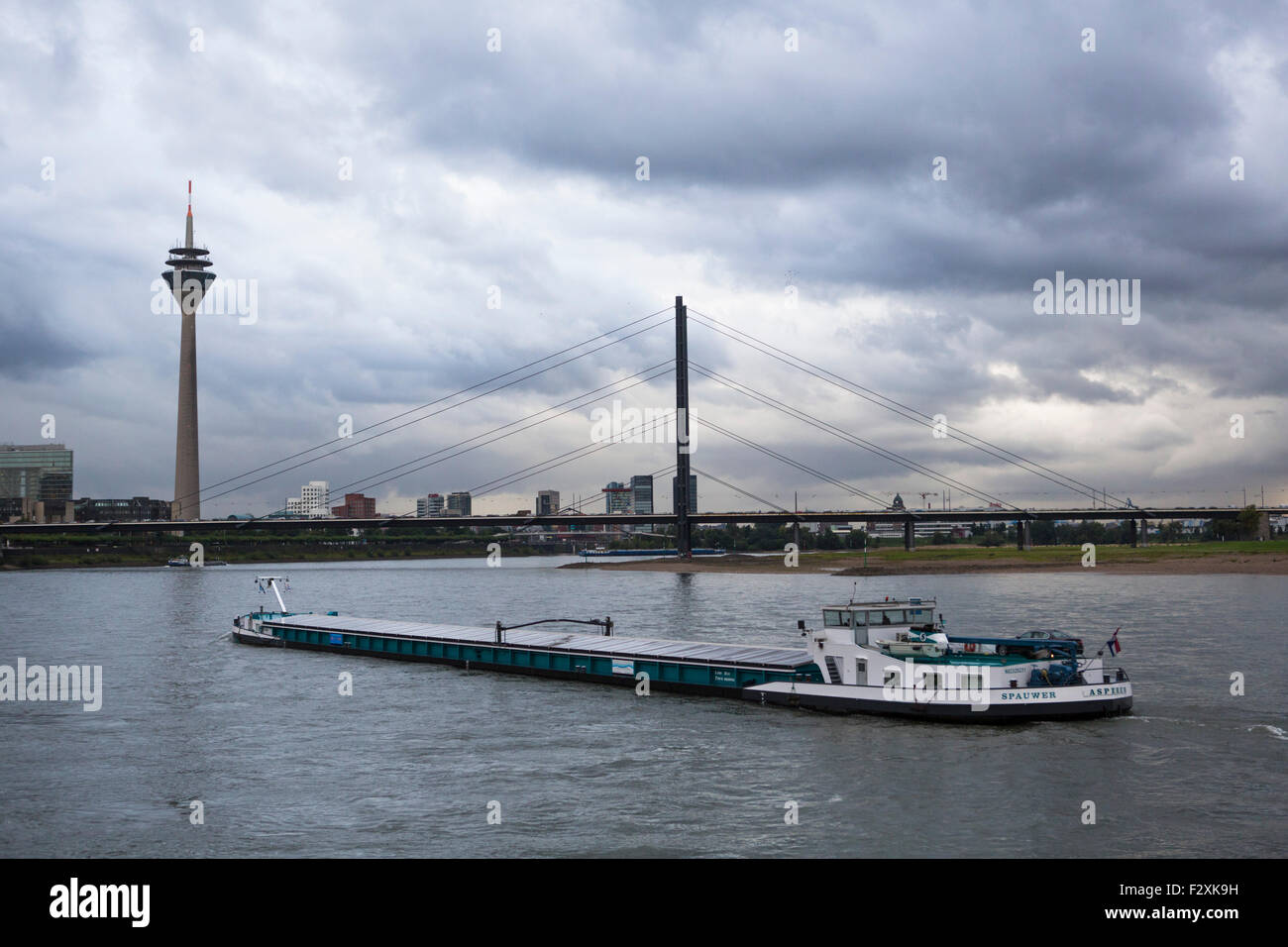 Rhine transport ship passing Düsseldorf at the Rhine in Germany  with a heavy cloudy sky Stock Photo