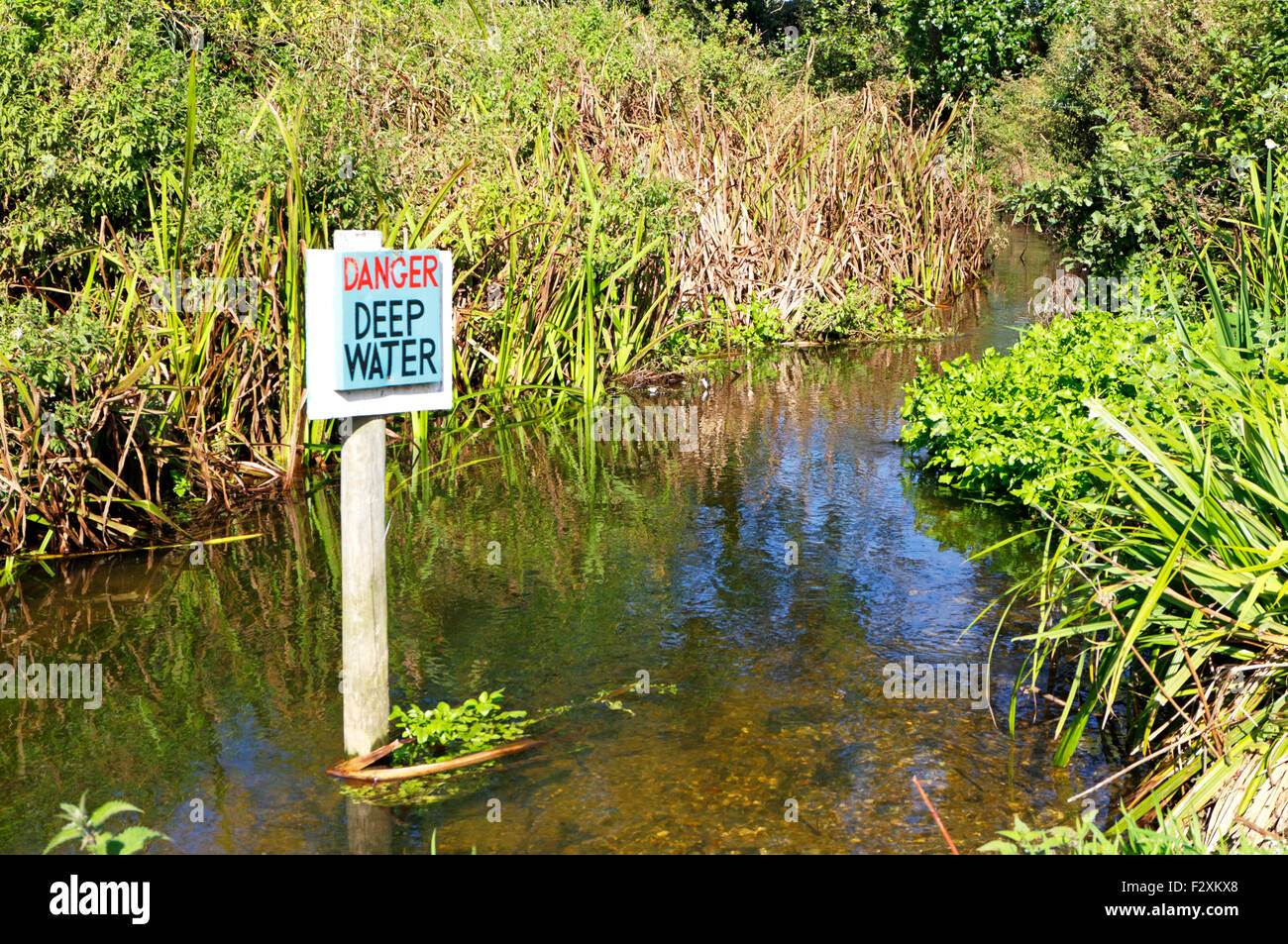 Danger - Deep Water sign in the River Glaven at Glandford, Norfolk, England, United Kingdom. Stock Photo
