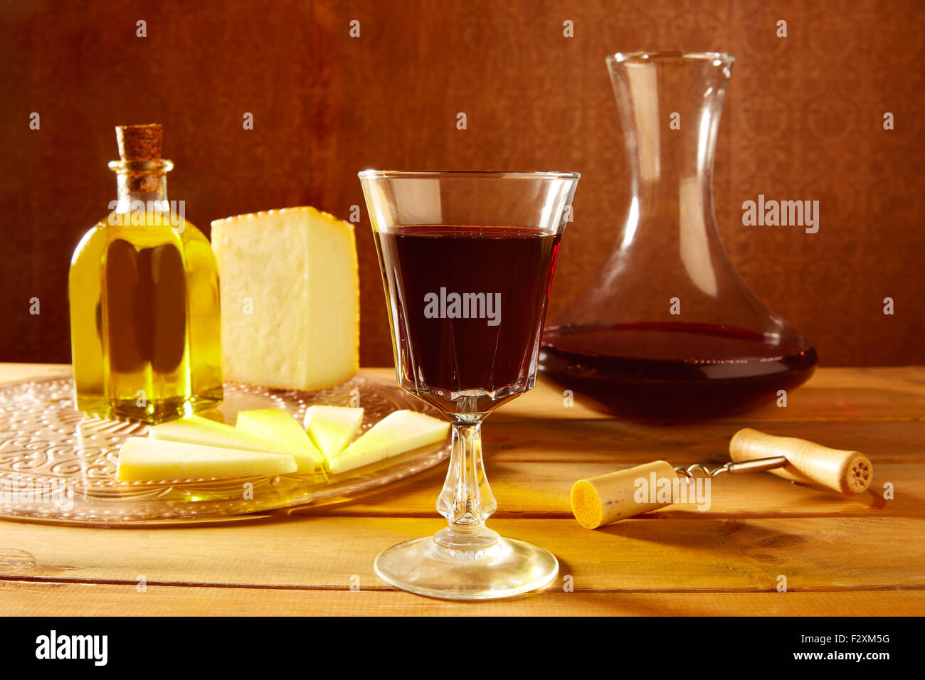 Manchego cheese from Spain with olive oil and red wine on wood Stock