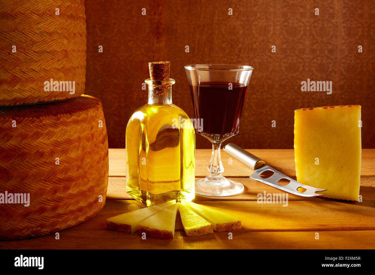 Manchego cheese from Spain with olive oil and red wine on wood Stock