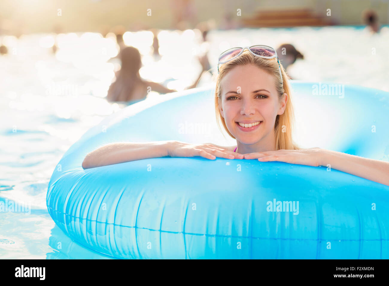 Beautiful young woman having fun outside in the swimming pool Stock Photo