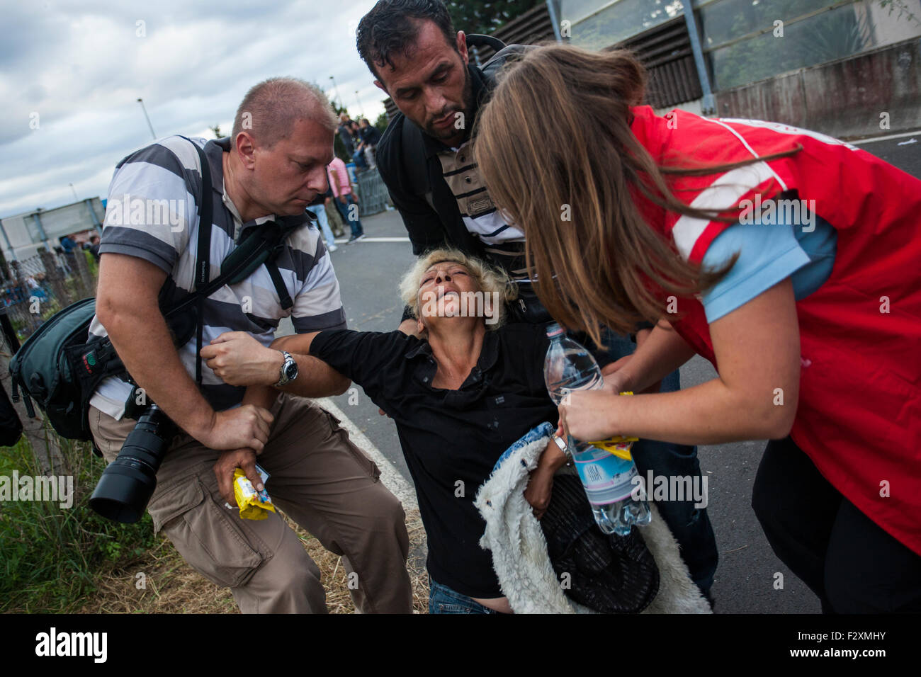 A female refugee passes out and needs medical attention for her broken hand after crossing the border at Rigonce, Slovenia. Stock Photo