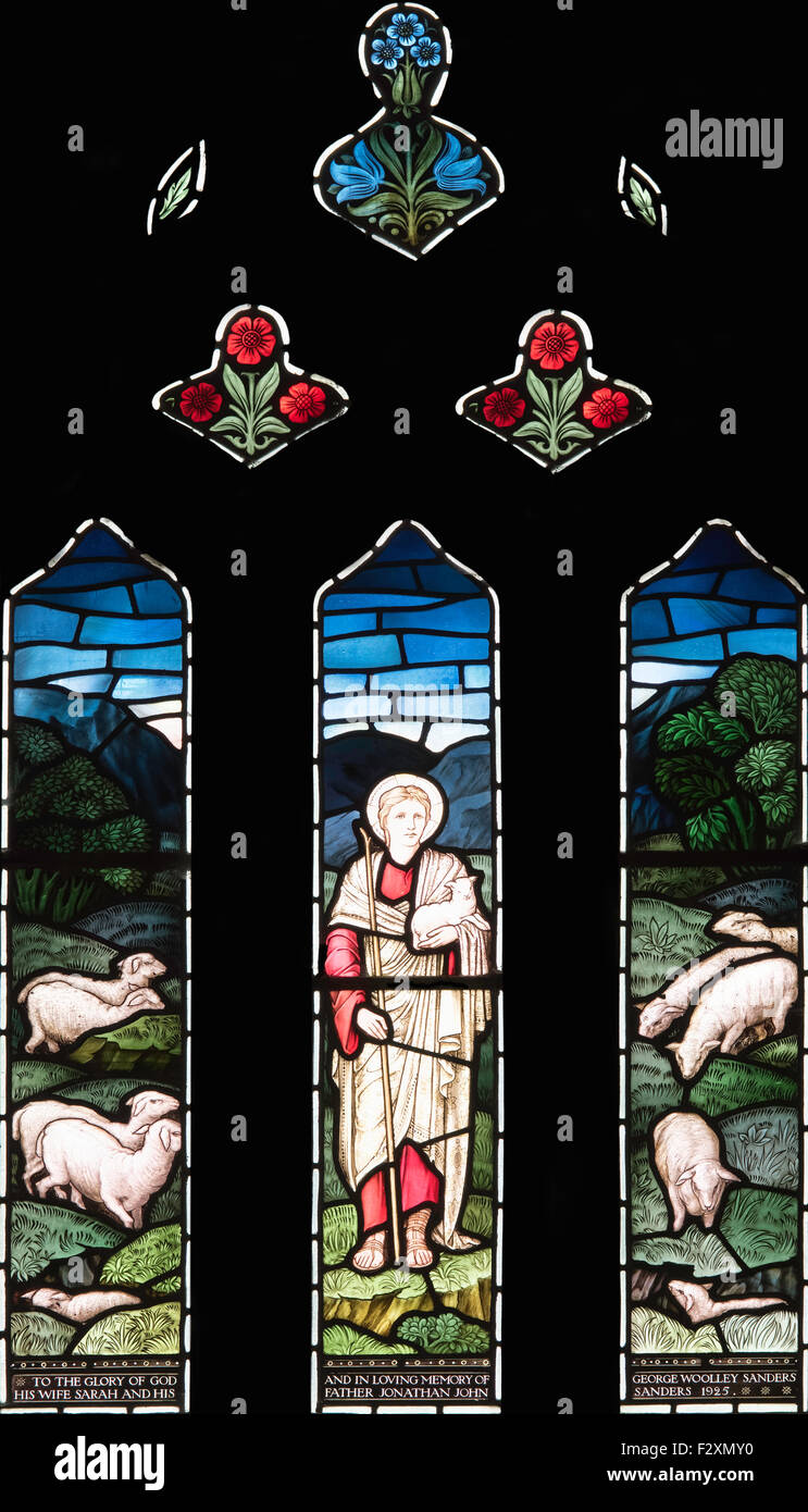A William Morris stained glass window depicting Christ the Good Shepherd Tending his Sheep, Lockton Church, North Yorkshire, UK Stock Photo