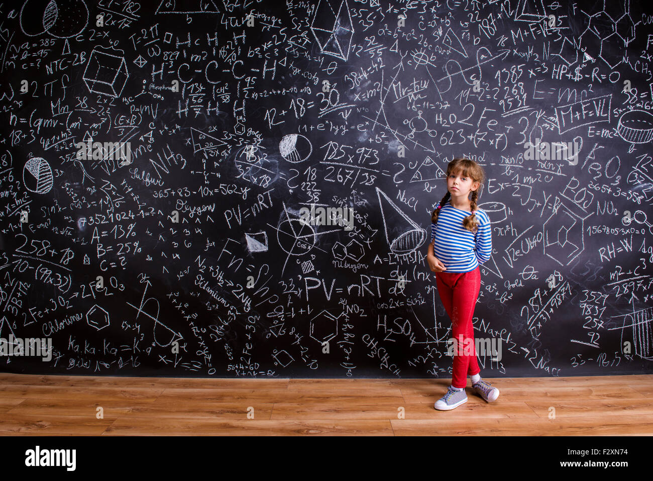 Cute Little Girl In Front Of Big Blackboard Stock Photo - Alamy