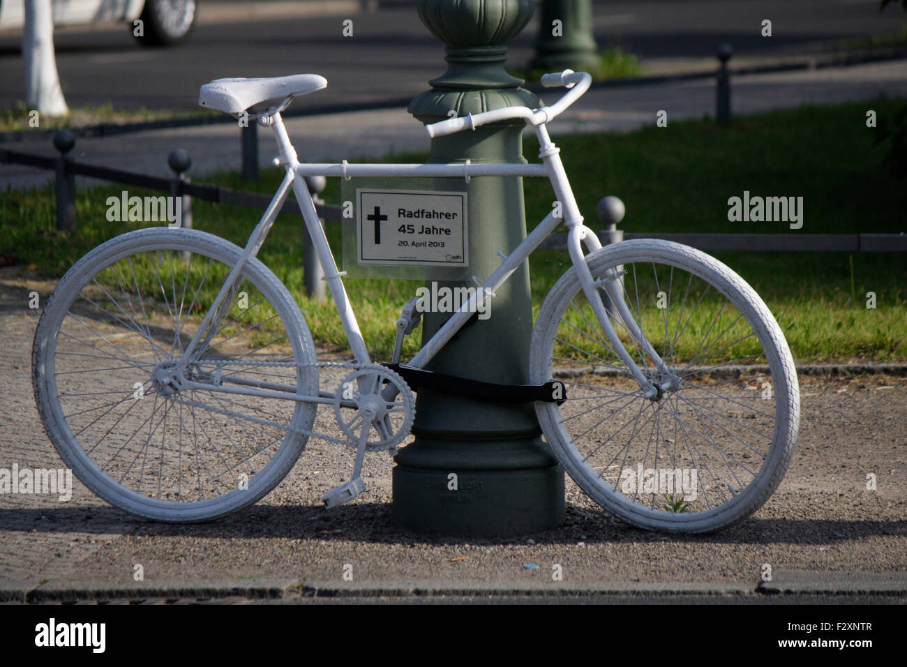 ein weisses Fahrrad als Mahnmal an dem Ort, an dem ein Fahrradfahrer durch einen Verkehrsunfall gestorben ist, Berlin. Stock Photo