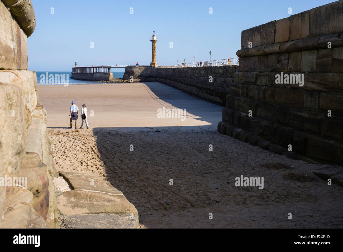 Early walkers on the pristine sands of West Cliff Beach, Whitby, North Yorkshire, England, UK Stock Photo