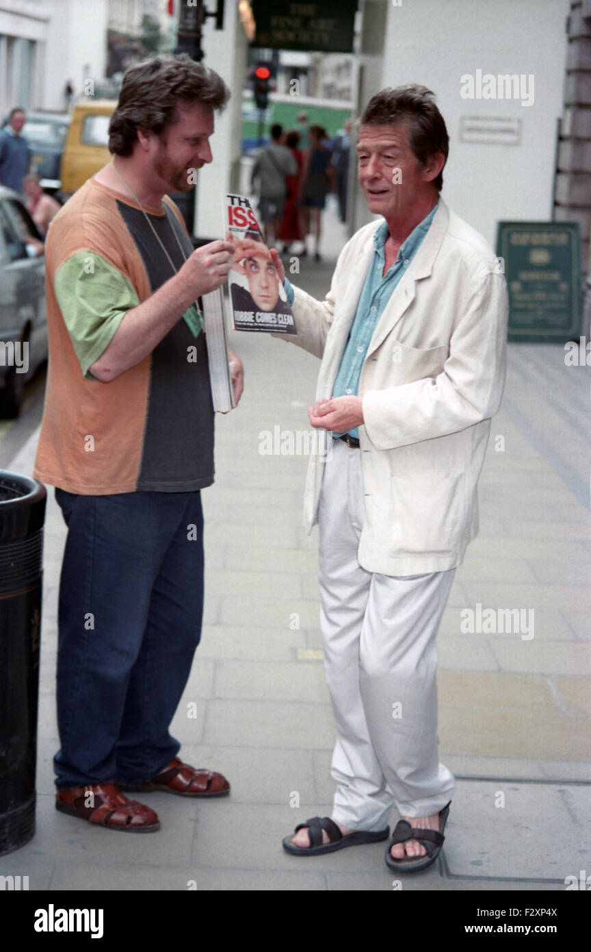John Hurt and female companion in Bond street  john buys a big issue from homeless vendor 5 pics (credit image© Jack Ludlam) Stock Photo
