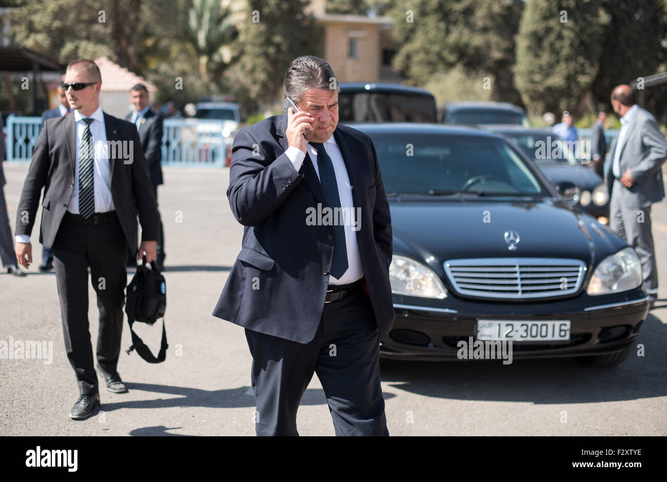 Amman, Jordan. 22nd Sep, 2015. German Economy Minister Sigmar Gabriel, surrounded by security staff, talks on his mobile phone before boarding a plane headed back to Berlin, Germany, at the airport in Amman, Jordan, 22 September 2015. Gabriel was briefed on the situation of the many migrants from Syria currently seeking refuge in Jordan during his two-day visit to the country. Photo: BERND VON JUTRCZENKA/dpa/Alamy Live News Stock Photo