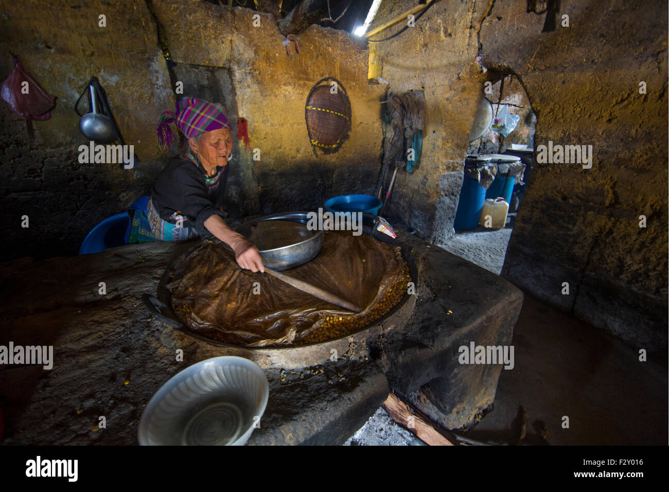 Woman of the black Hmong hill tribe in Vietnam brewing alcohol in her house Stock Photo