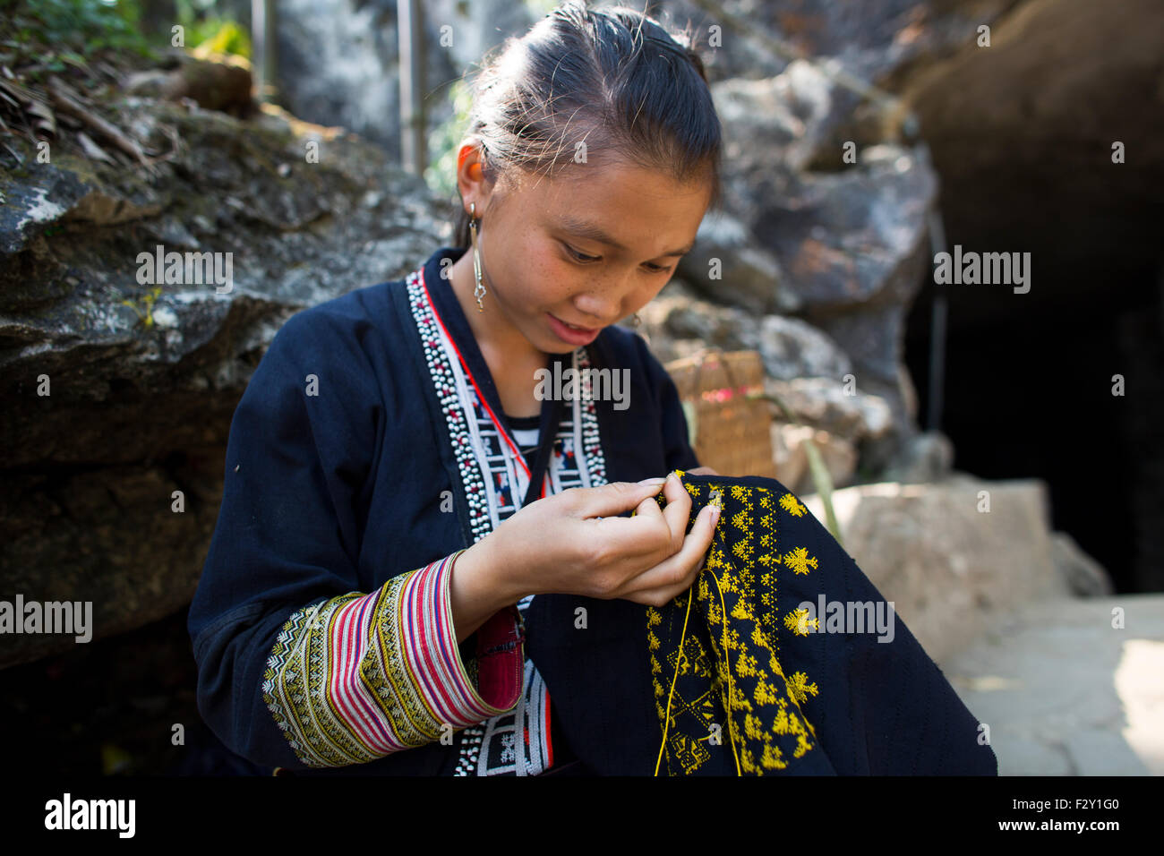 Girl of the ethnic 'black Hmong' tribe embroider traditional clothing Stock Photo