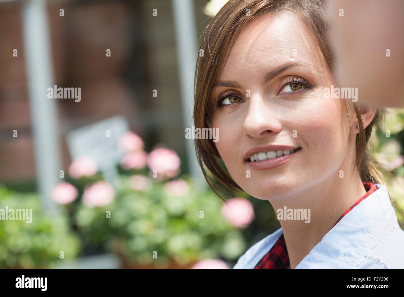 A young woman looking sideways at a companion. Stock Photo
