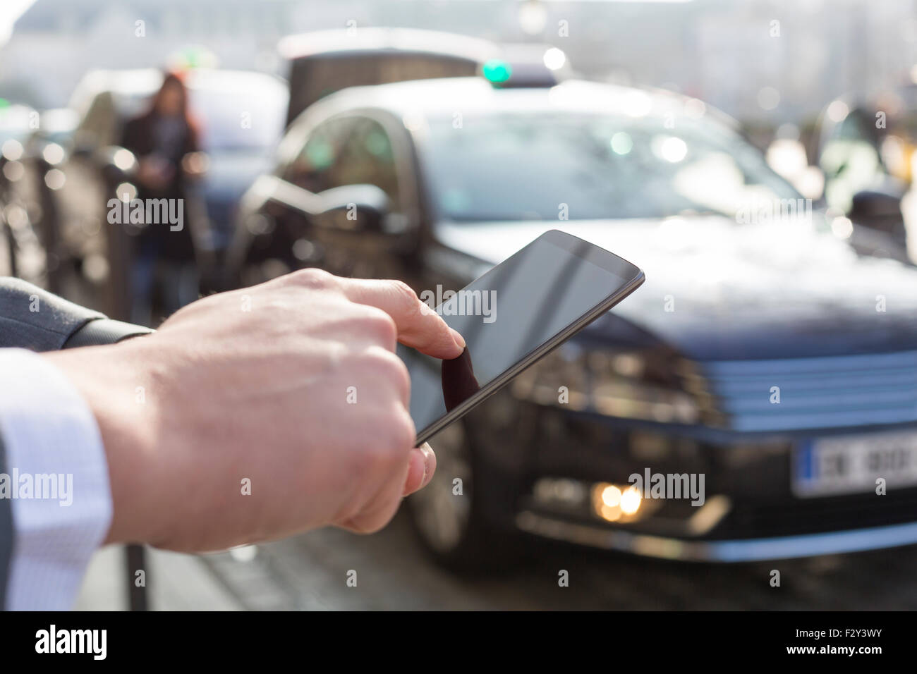 Man orders a taxi from his mobile phone. Close-up hands Stock Photo