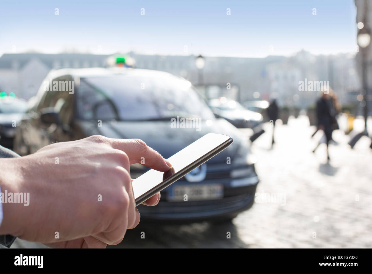 Man orders a taxi from his mobile phone. Close-up hands Stock Photo