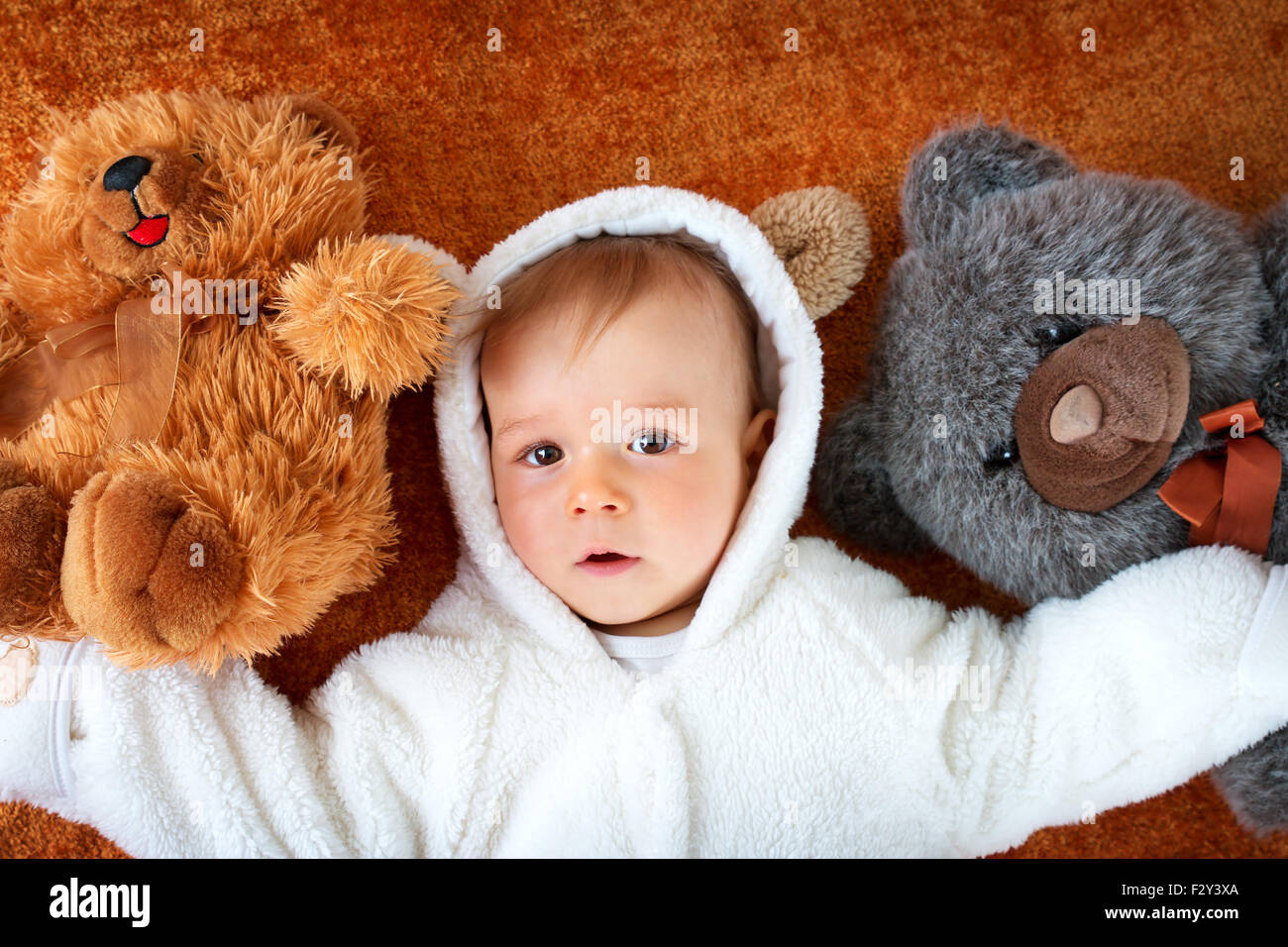 Little baby in bear costume with plush toys Stock Photo Alamy