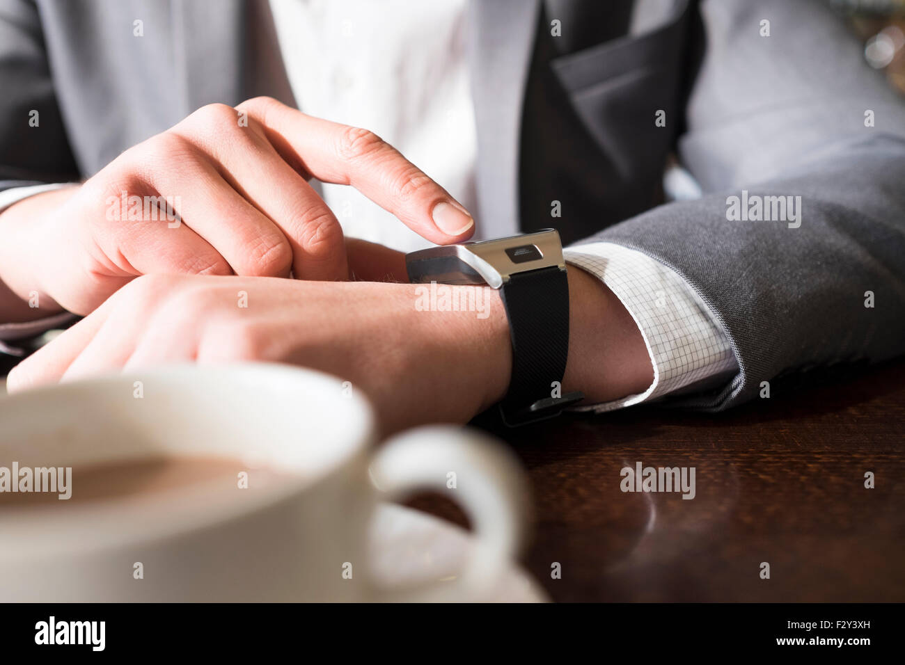 In coffee bar a man using his smartwatch. Close-up hands Stock Photo