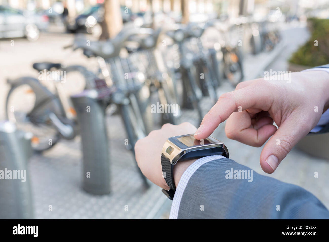 Man using a smartwatch in front of Velib Station, Paris Stock Photo