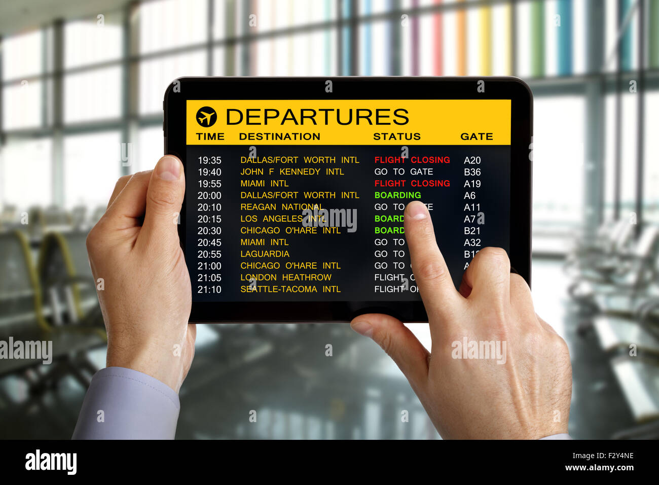 Digital tablet in airport with flight schedule and departure and gate information Stock Photo