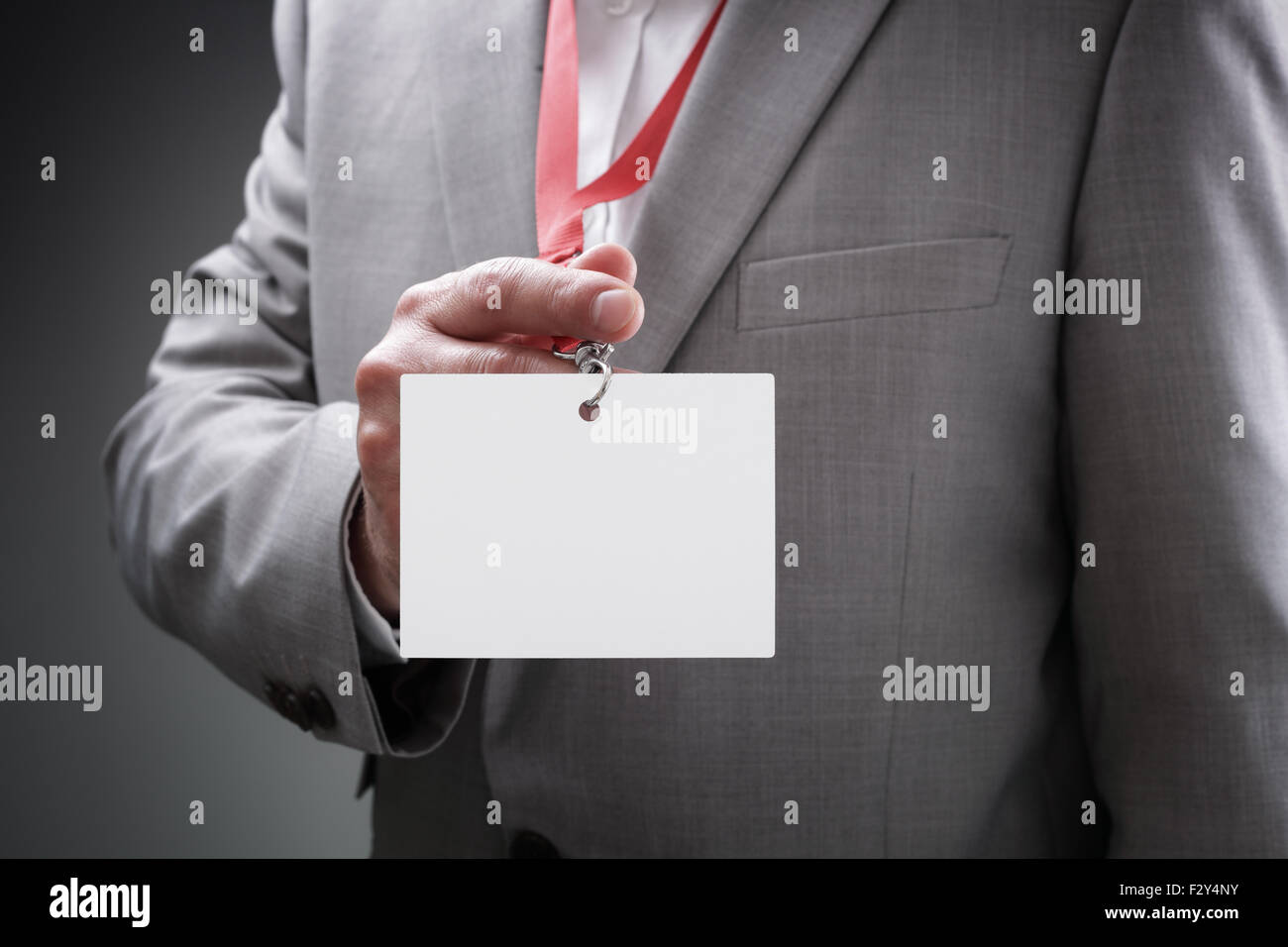 Businessman holding blank ID badge Stock Photo