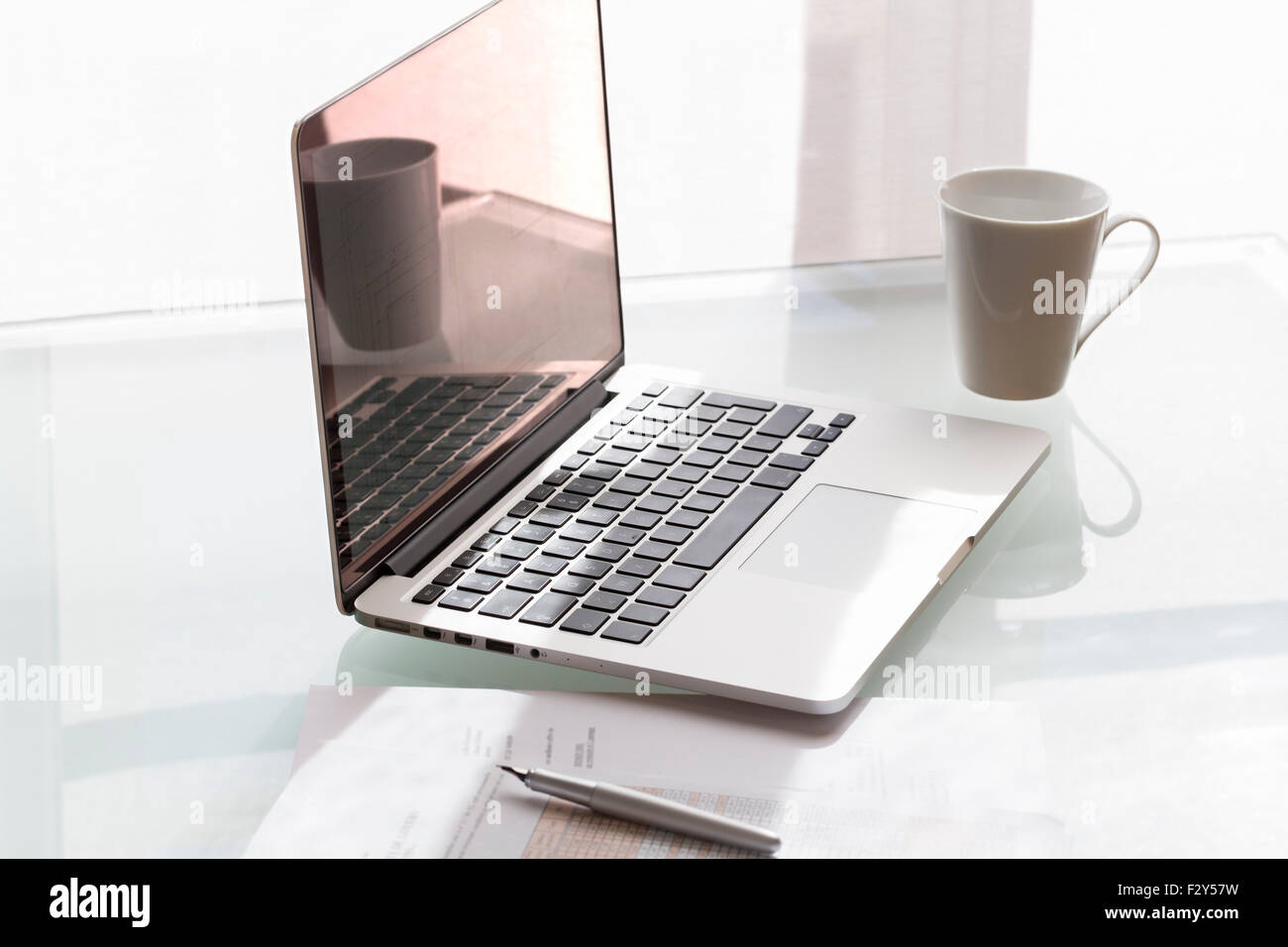 Laptop on modern glass table in office Stock Photo