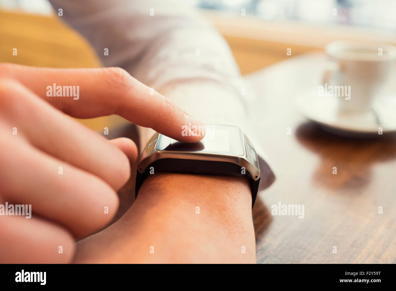 Man in a bar using smart watch. Close-up finger. Vintage filter Stock Photo
