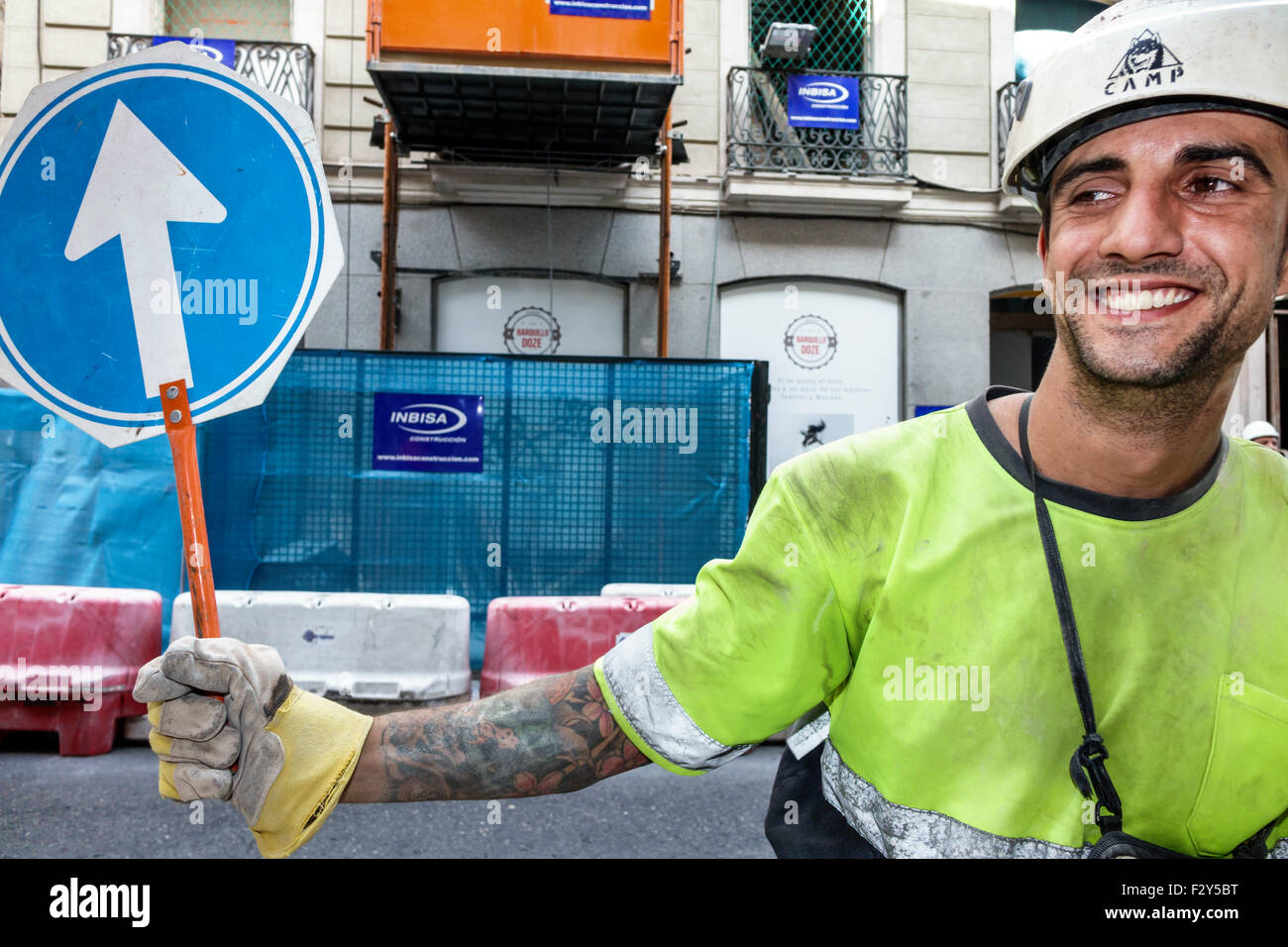 Madrid Spain,Hispanic Centro,Hispanic man men male,construction worker,job,directing traffic,sign,arrow,hard hat,Spain150701124 Stock Photo