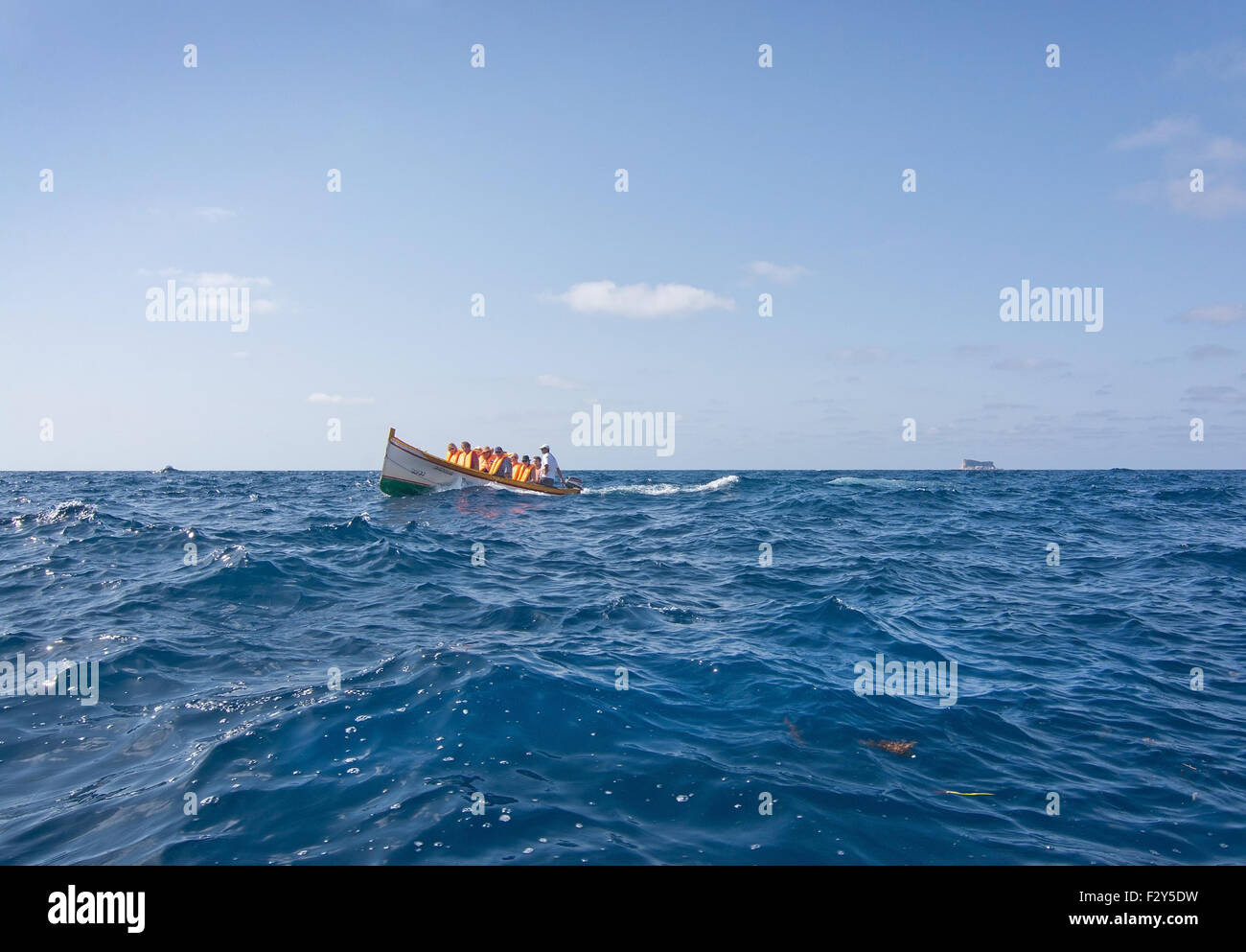 Boat with tourists in the blue water near of popular tourist attraction Blue Grotto in Malta. Stock Photo