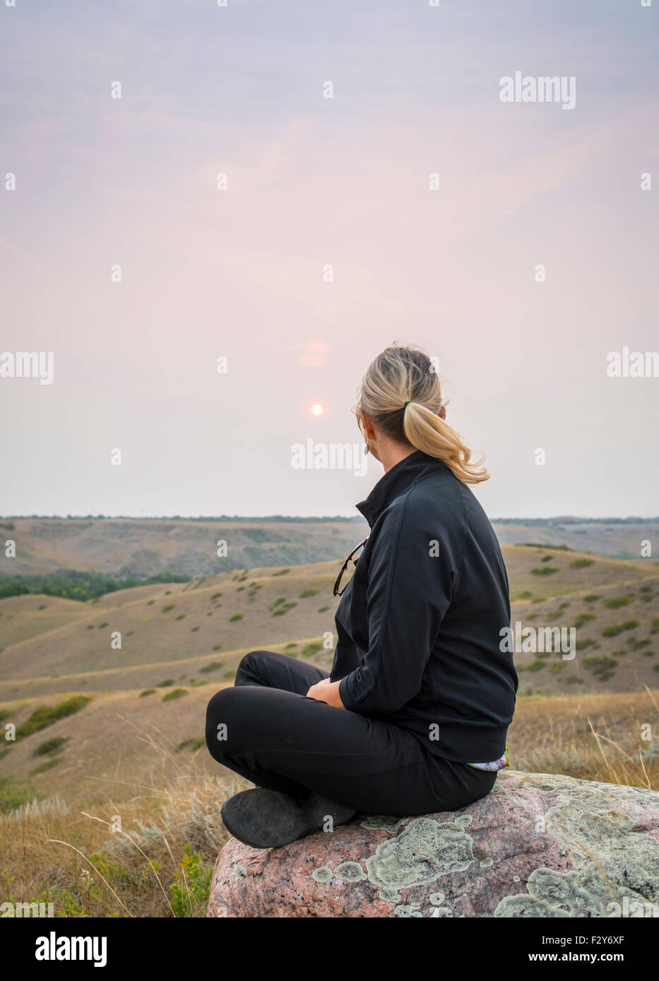 woman sitting on rock in coulees of southern alberta Stock Photo