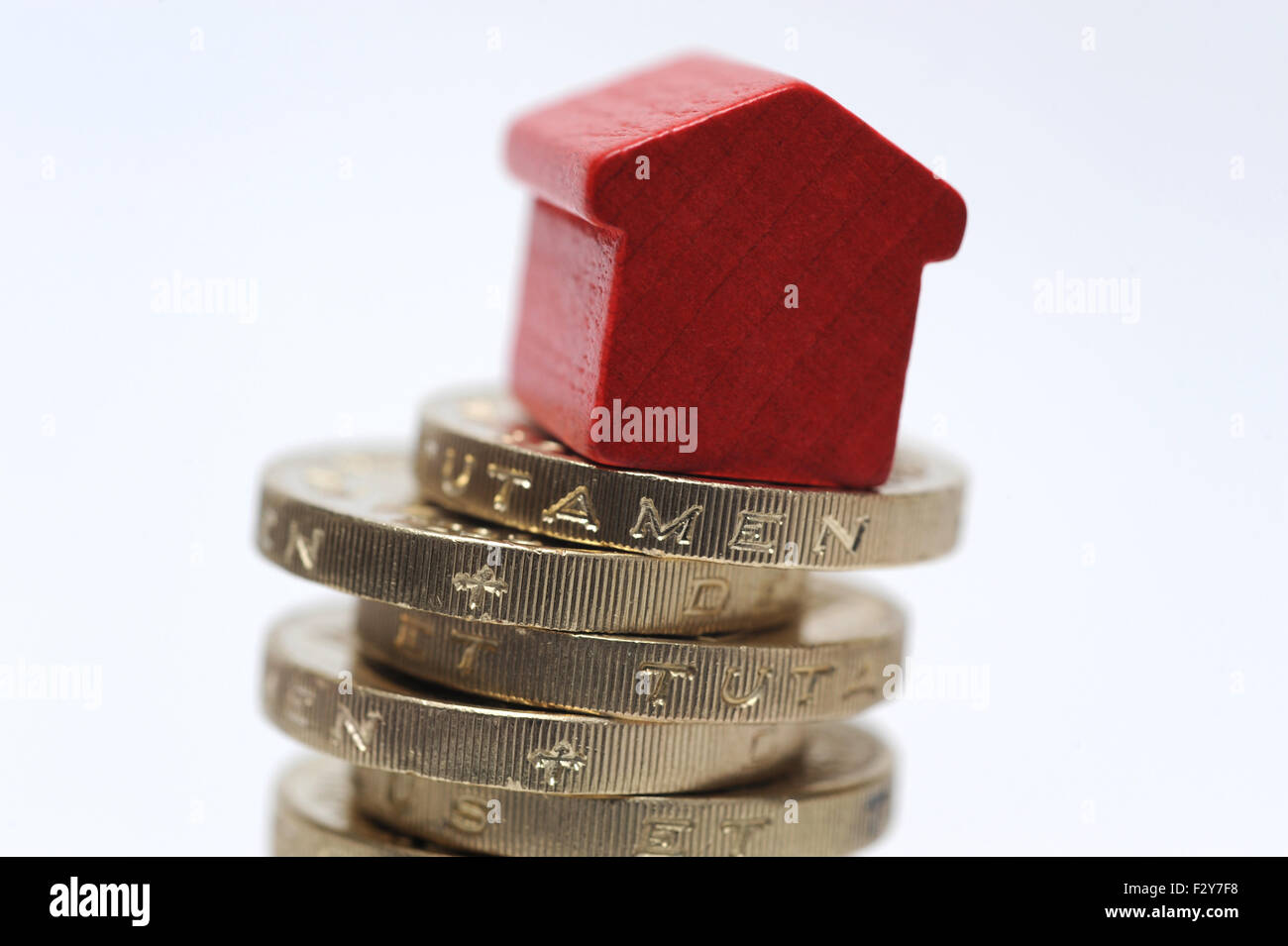 MODEL HOUSE ON STACK OF ONE POUND COINS RE HOME BUYERS BUYING HOUSING LADDER PROPERTY MARKET MORTGAGES INCOMES INTEREST RATES UK Stock Photo