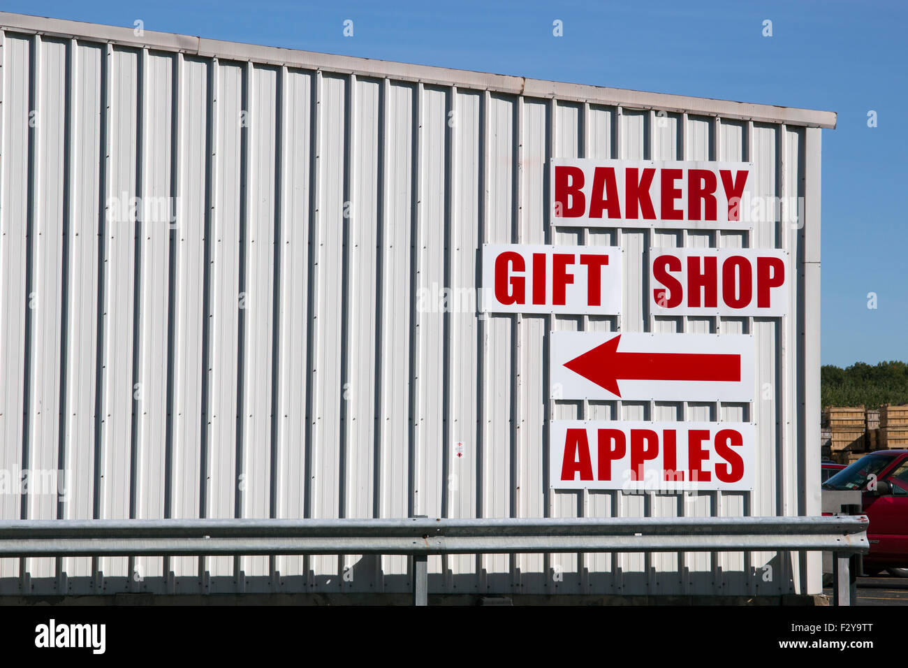 Bakery gift shop arrow apples sign on side of building Stock Photo Alamy