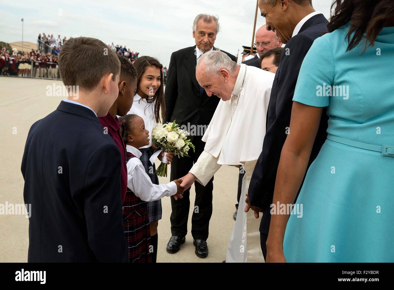 Pope Francis greets Catholic school children as President Barack Obama looks on during the arrival ceremony at Joint Base Andrews September 23, 2015 in Camp Springs, Maryland. This is the first visit by Pope Francis to the United States. Stock Photo