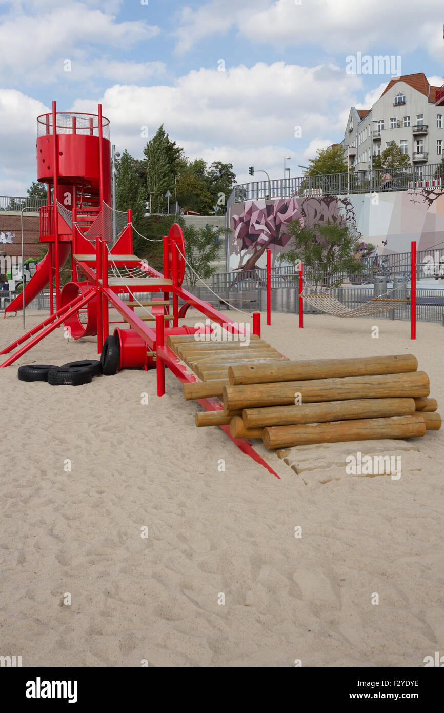 kids playground with red slide, climber and sandpit Stock Photo