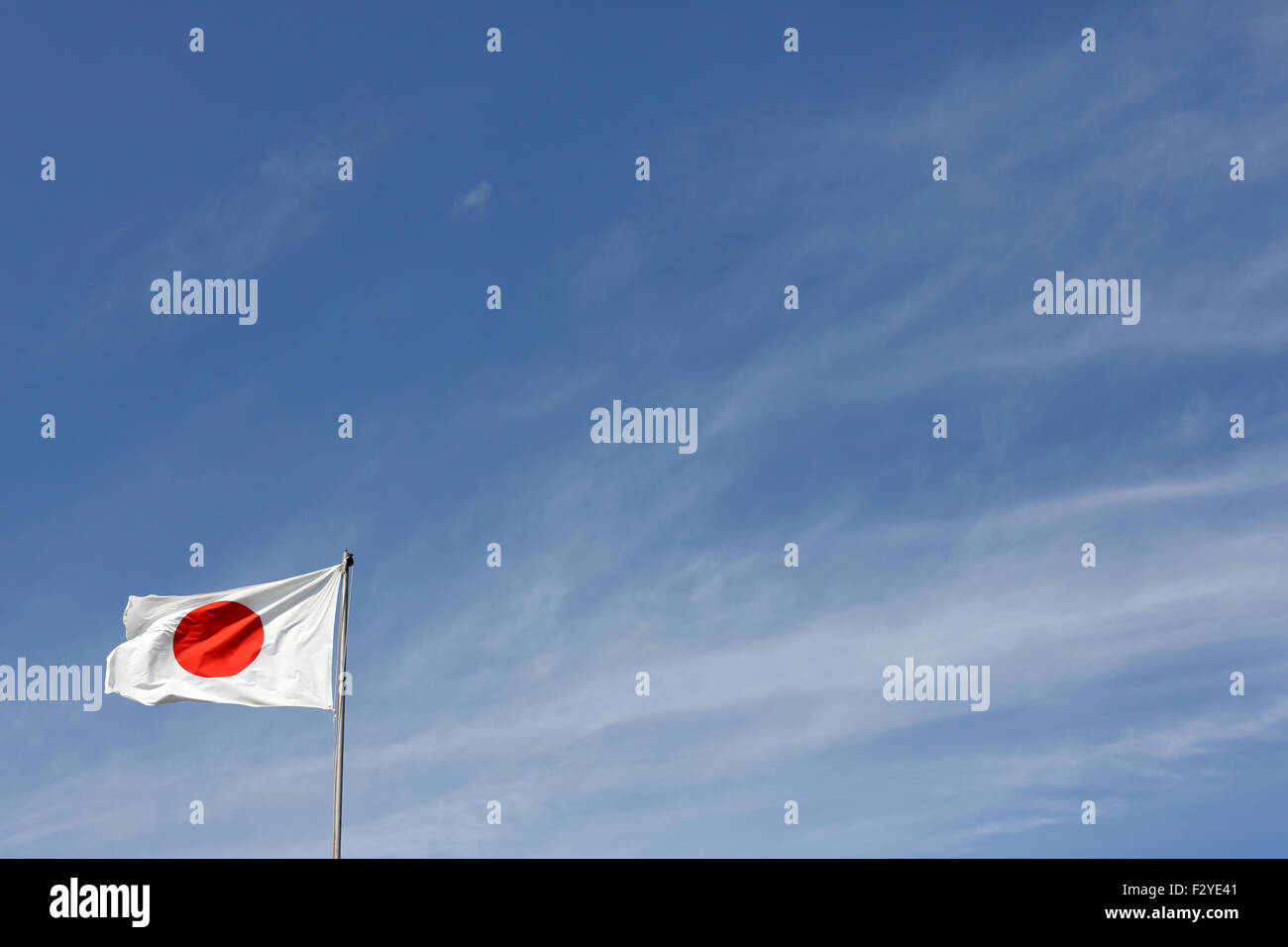 Japanese flag in wind against clear blue sky Stock Photo
