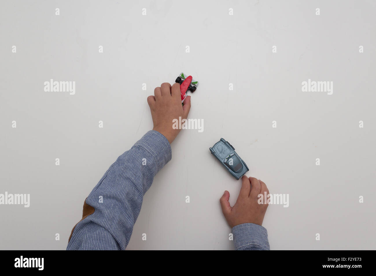 kid playing with toy cars on white background - children hands Stock Photo