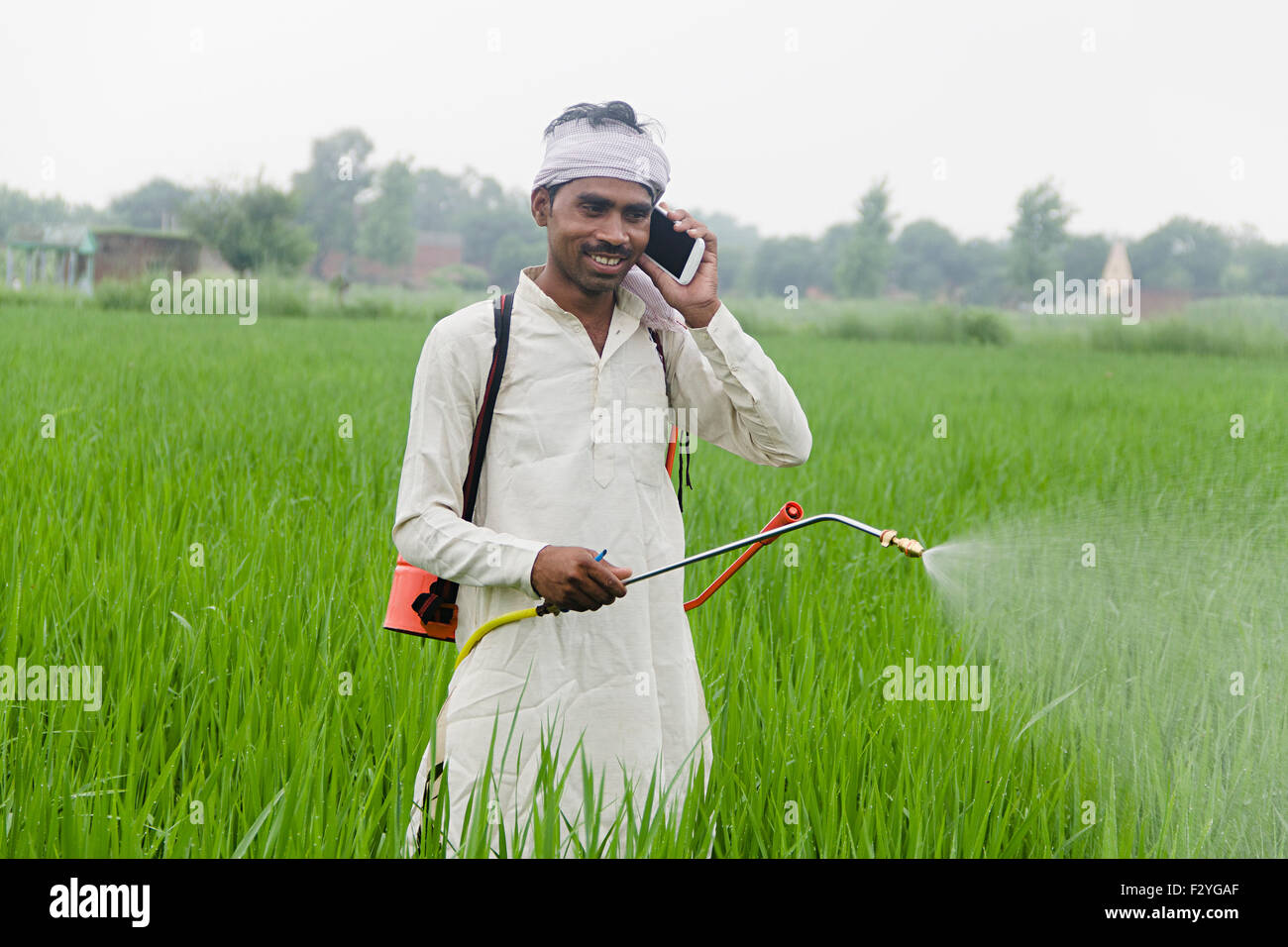 1 indian rural farmer Farm Plants  Spraying and talking  Mobile Phone Stock Photo
