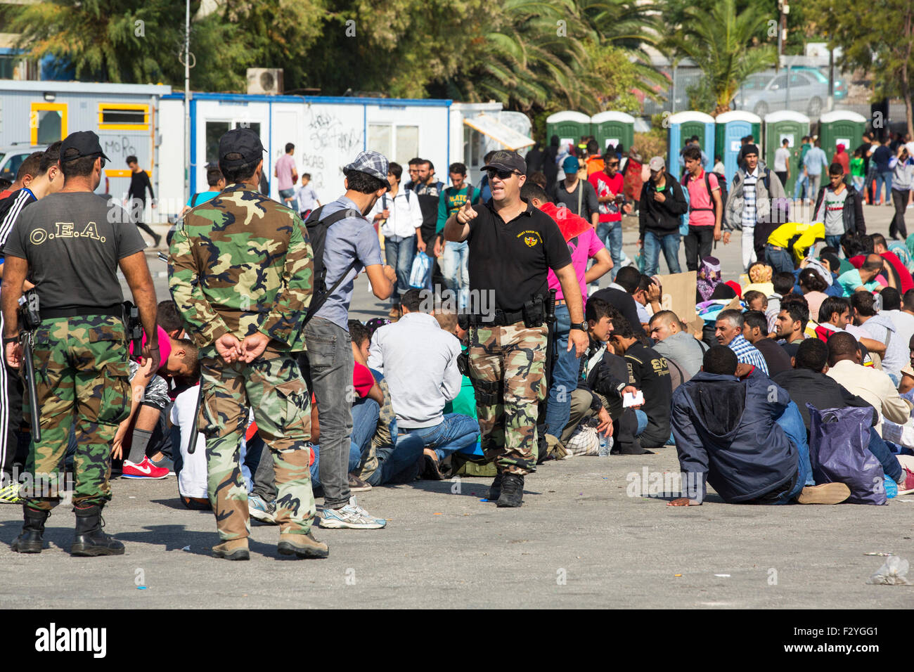 Lesvos, Greece. 25th Sep, 2015. Greek Police guard illegal migrants that have landed from Turkey, smuggled by people traffickers on the island of Lesbos. The migrants are mainly Syrian and Afghani, fleeing the war. People traffickers in Turkey are charging the migrants $1500-$2000 per person for the half hour crossing. Credit:  Ashley Cooper/Alamy Live News Stock Photo