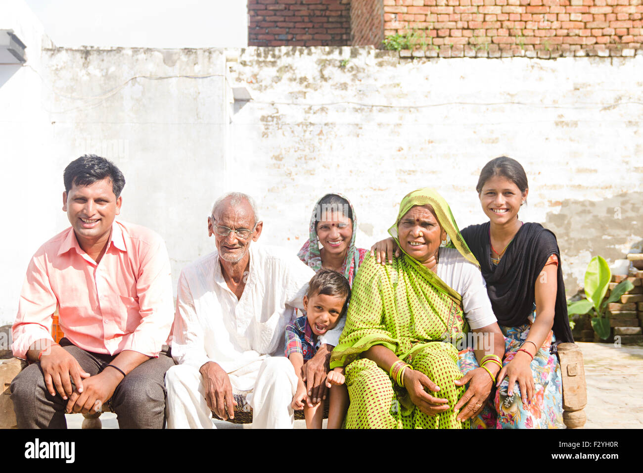 indian group crowds rural villager family sitting Home Charpai Stock Photo