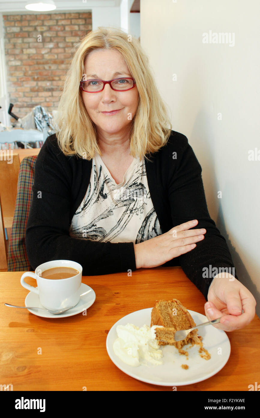 Older attractive Irish woman drinking coffee in cafe, County Kerry Ireland Stock Photo