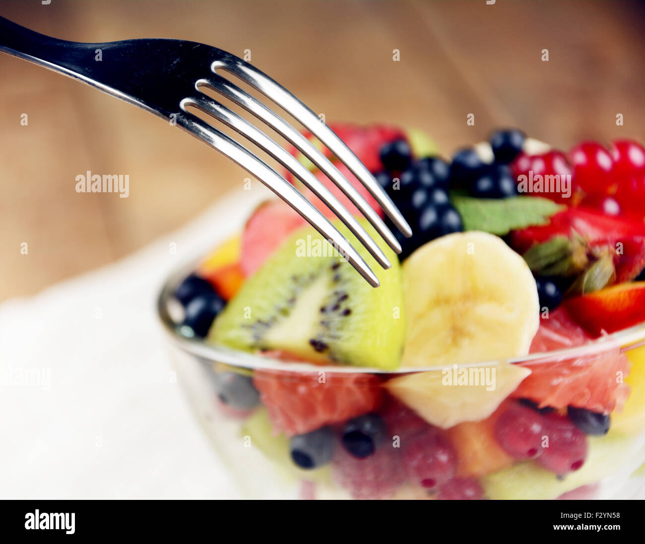 Fresh tasty fruit salad in the bowl on the wooden table Stock Photo