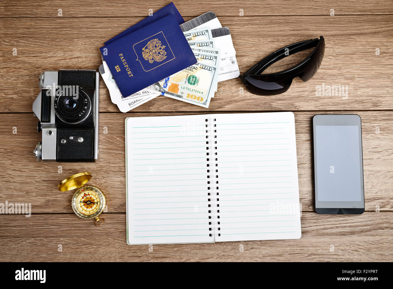 Business travel and tourism concept: air tickets or boarding pass, passports, smartphone, compass, vintage camera, sunglasses Stock Photo