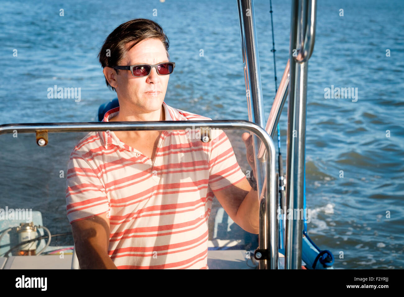 Young man steering boat hi-res stock photography and images - Alamy