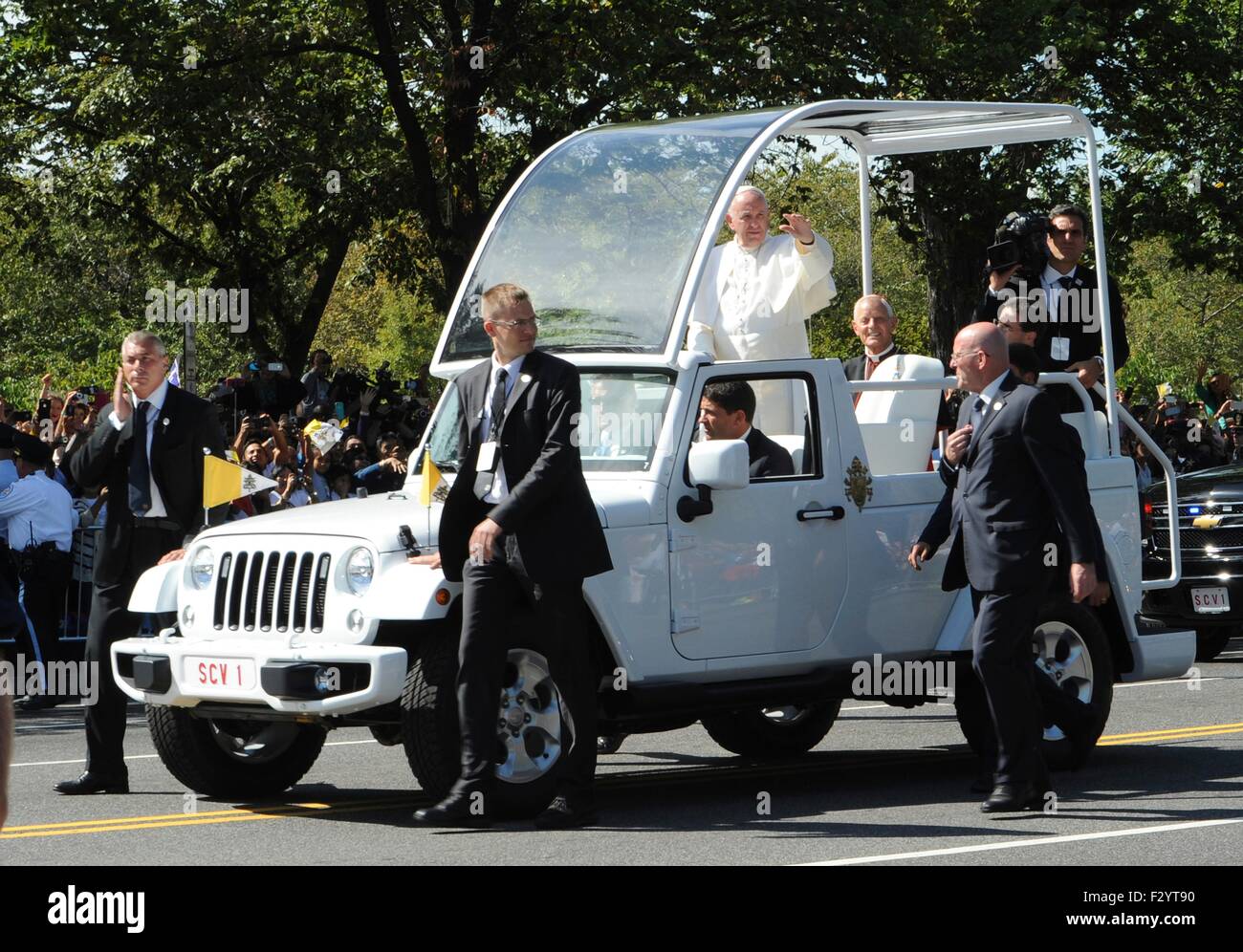 Pope Francis waves to crowds gathered for his motorcade along Pennsylvania Avenue to the Capitol September 23, 2015 in Washington, DC. This is the first visit by Pope Francis to the United States. Stock Photo