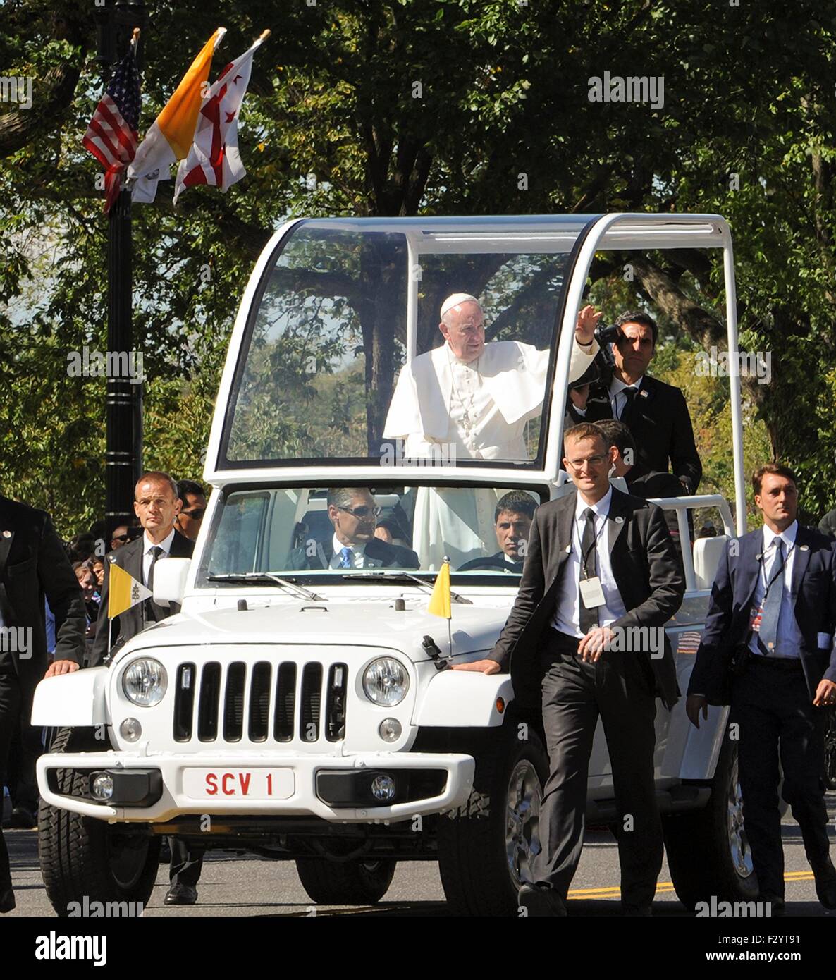Pope Francis waves to crowds gathered for his motorcade along Pennsylvania Avenue to the Capitol September 23, 2015 in Washington, DC. This is the first visit by Pope Francis to the United States. Stock Photo