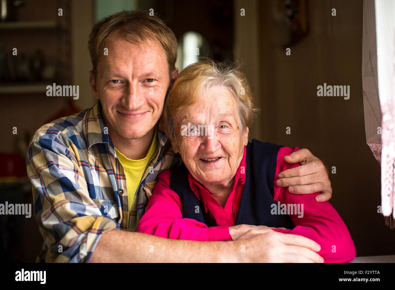 Portrait of happy elderly woman with adult grandson. Stock Photo
