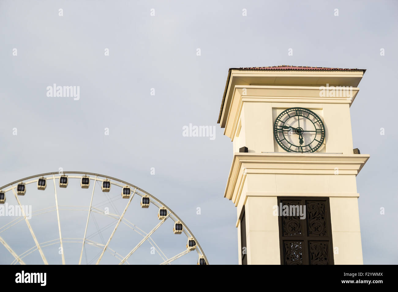 Clock tower with ferris wheel and sky background Stock Photo - Alamy