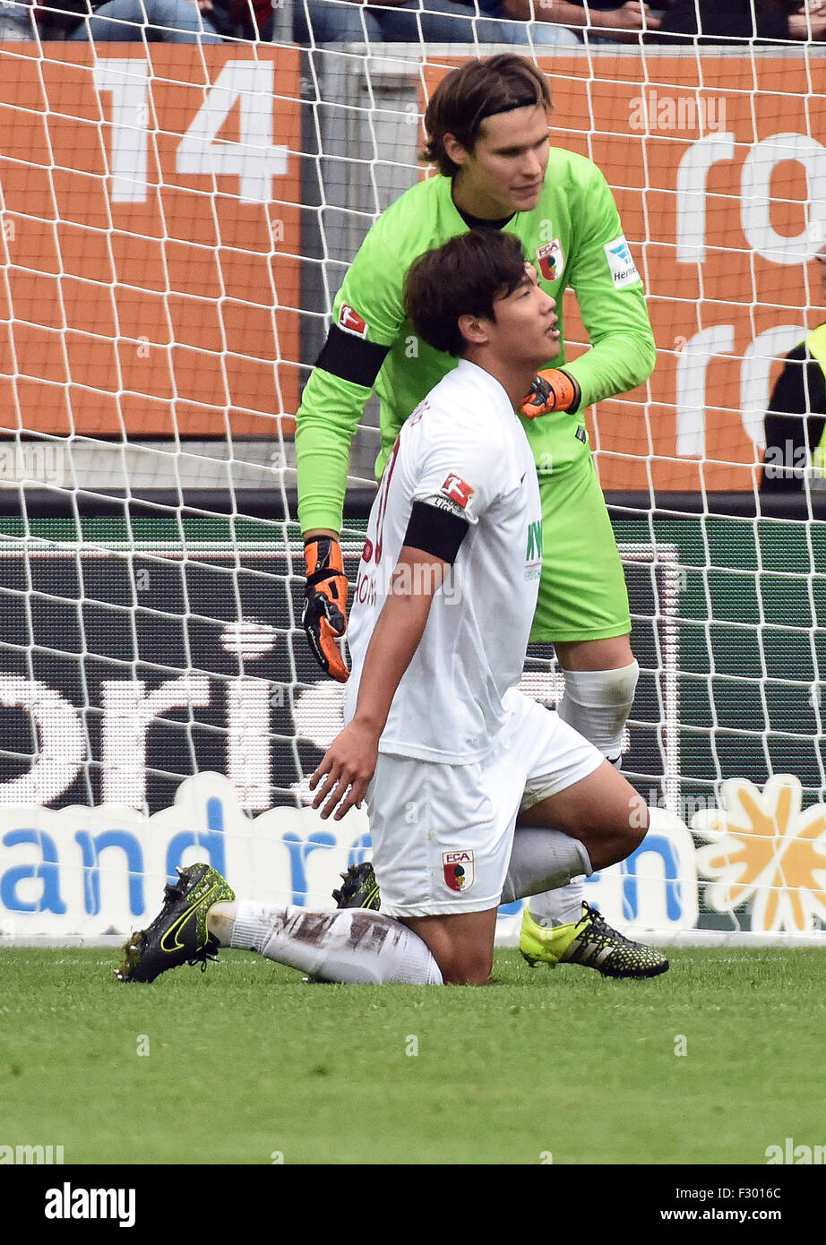 Augsburg, Germany. 26th Sep, 2015. Augsburg's goalkeeper Marwin Hitz (R) comforts teammate Jeong-Ho Hong after the latter caused a penalty kick during the German Bundesliga soccer match between FC Augsburg and 1899 Hoffenheim in Augsburg, Germany, 26 September 2015. Photo: STEFAN PUCHNER/dpa (EMBARGO CONDITIONS - ATTENTION: Due to the accreditation guidelines, the DFL only permits the publication and utilisation of up to 15 pictures per match on the internet and in online media during the match.)/dpa/Alamy Live News Stock Photo