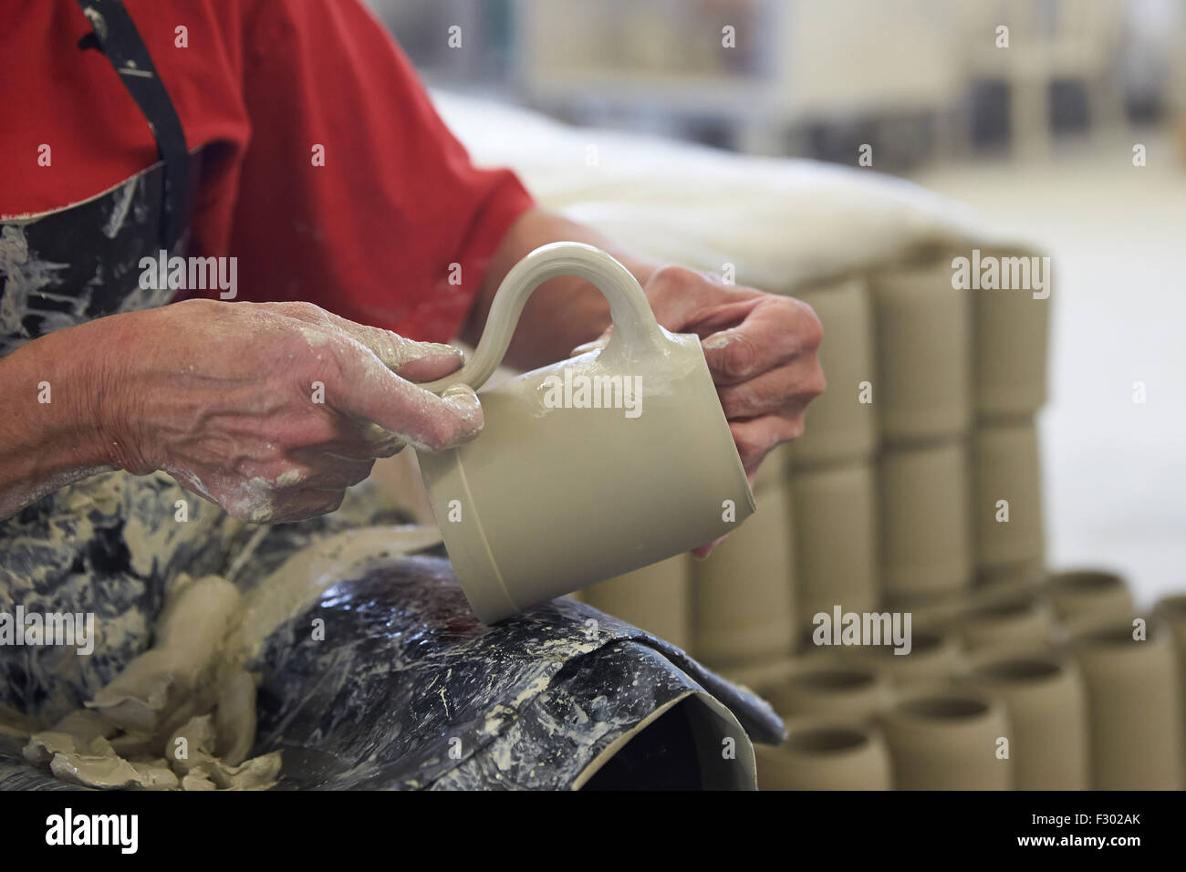 Mogendorf, Germany. 15th Sep, 2015. An unfinished beer mug made of clay is equipped with a handle in the production hall of the beer mug manufacturing company Klaus Stroeder GmbH & Co KG in Mogendorf, Germany, 15 September 2015. The beer mugs for the world's largest beer festival Oktoberfest in Munich are manufactured in this region. Photo: Thomas Frey/dpa/Alamy Live News Stock Photo