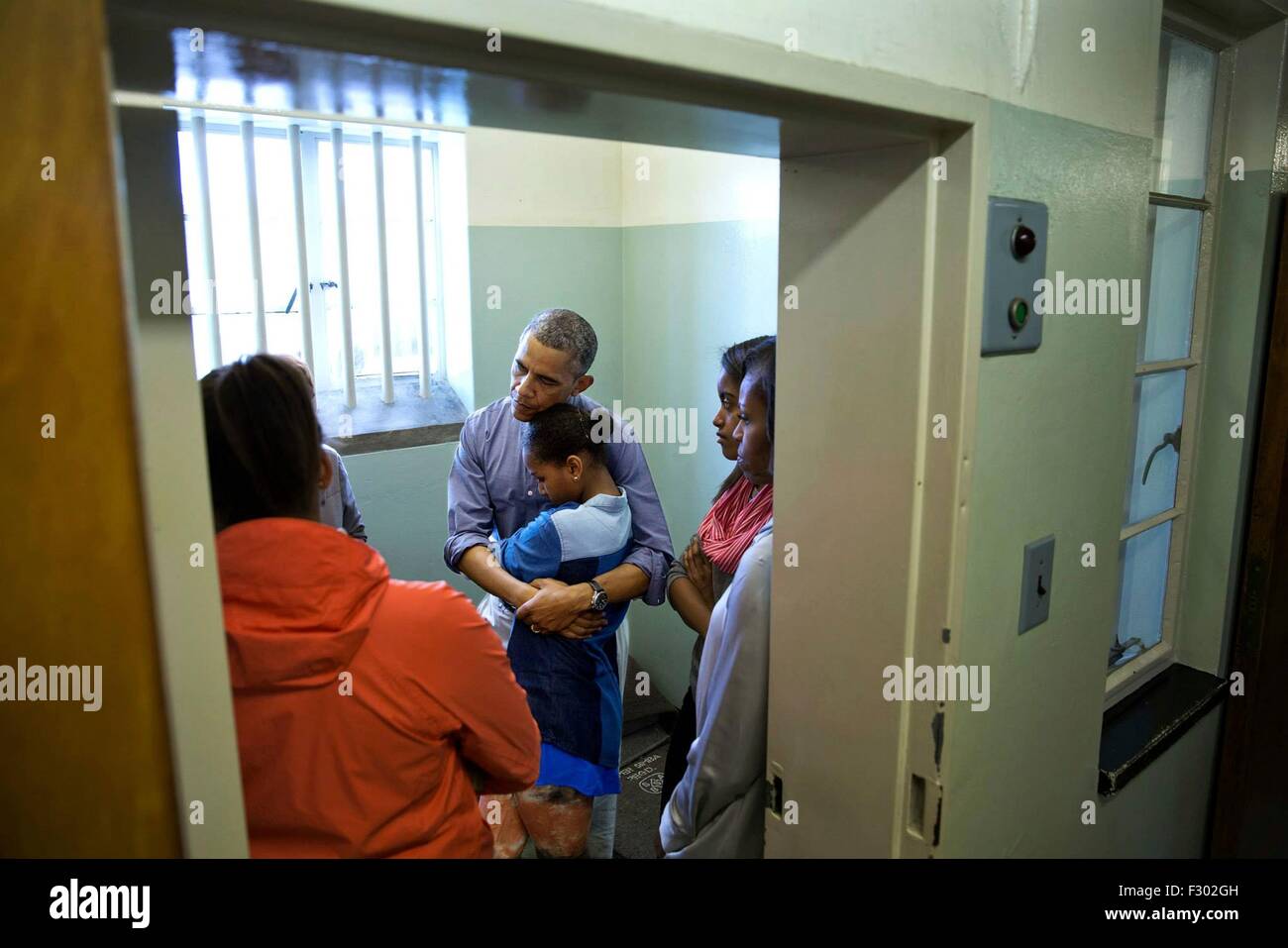 US President Barack Obama listens to former prisoner Ahmed Kathrada as he stands in former South African President Nelson Mandela's cell during a tour of Robben Island Prison on Robben Island June 30, 2013 in Cape Town, South Africa. Stock Photo