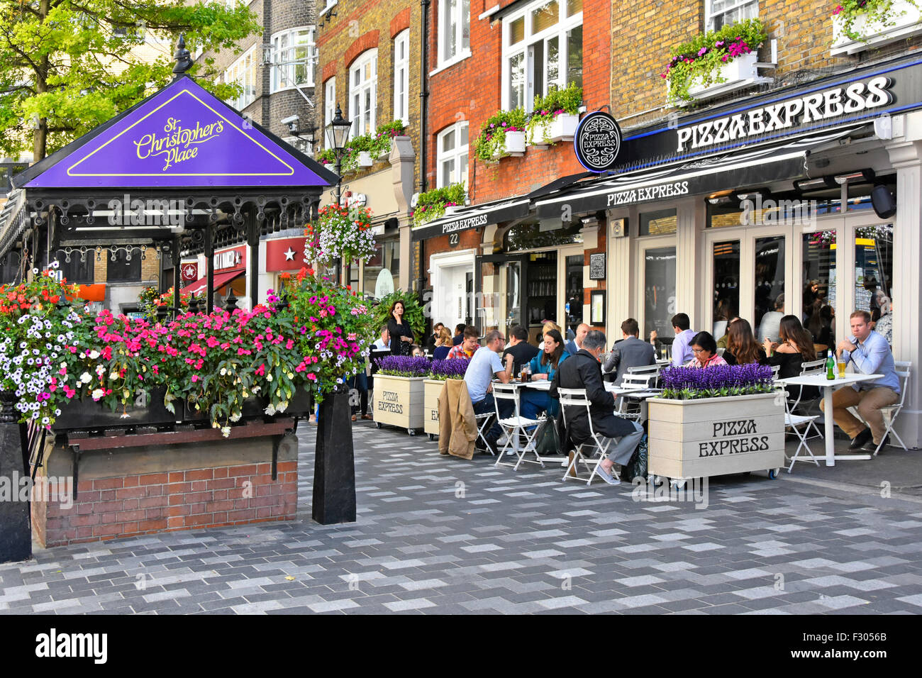 Pizza Express pizza restaurant with people eating out dining outdoors in St Christophers Place off Oxford Street alfresco dining London West End UK Stock Photo