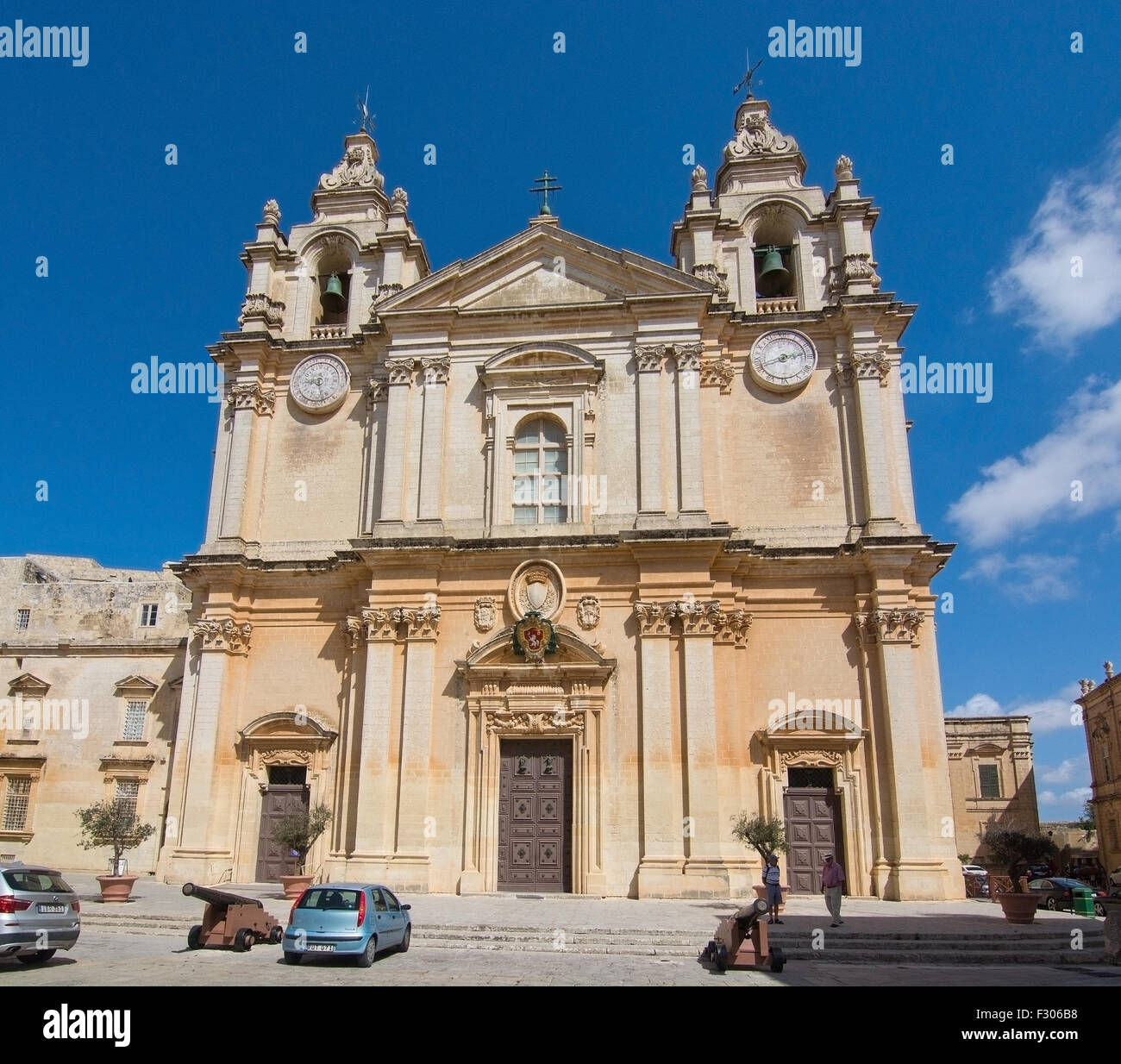 Baroque church building with iron cannons inside old city walls on a sunny day in September in Mdina, Malta. Stock Photo
