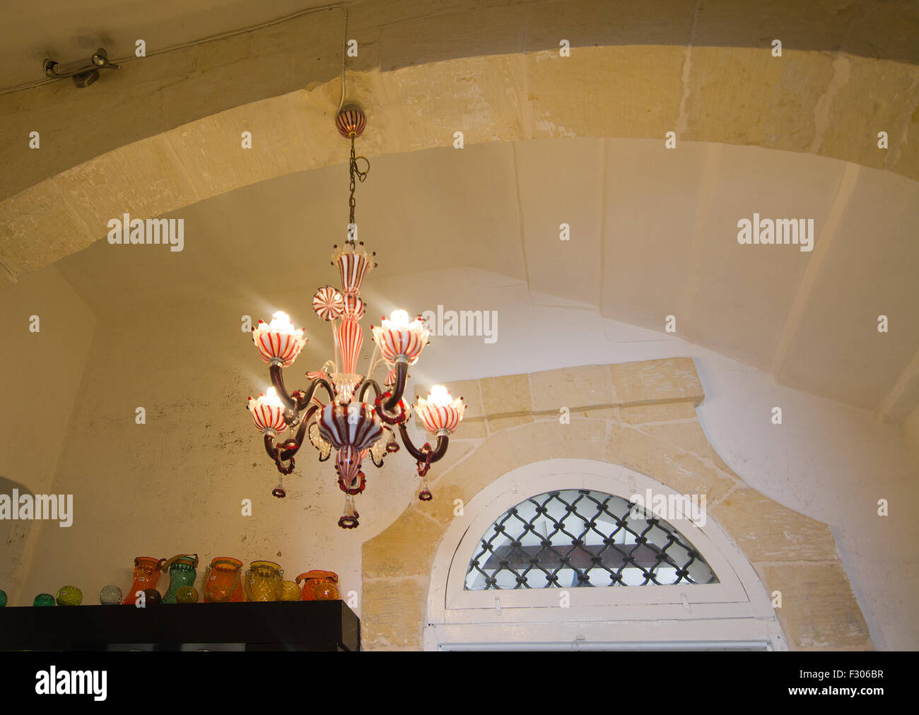 Beautiful red and white, handblown glass chandelier made by artisans in Malta on display in Mdina glass store. Stock Photo